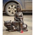 metal buddha statue sitting on tiger sculpture